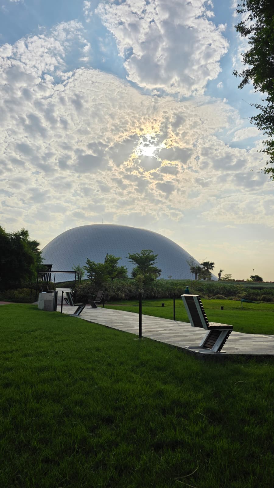A quiet park path beside green lawns and the dome
