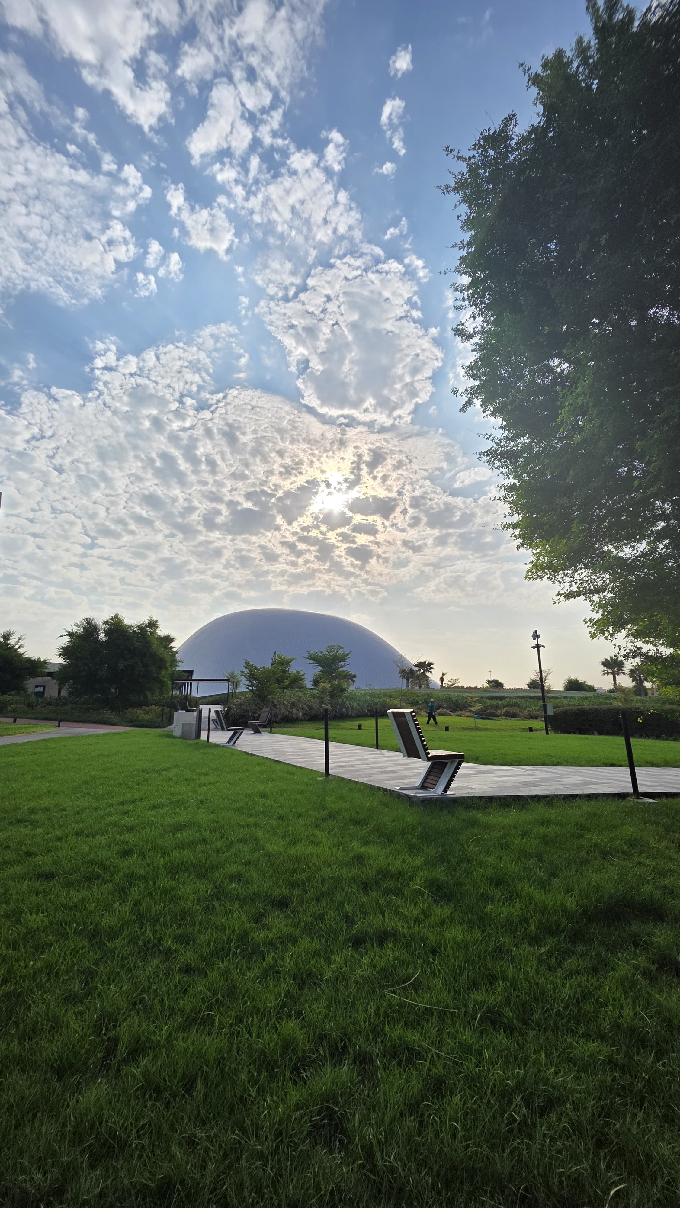 Green lawns, paths and the park’s pale dome